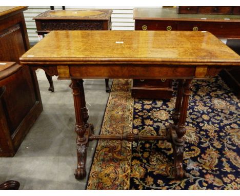 Victorian figured walnut veneered foldover card table on twin reeded standards, turned pole stretcher, on shaped supports wit