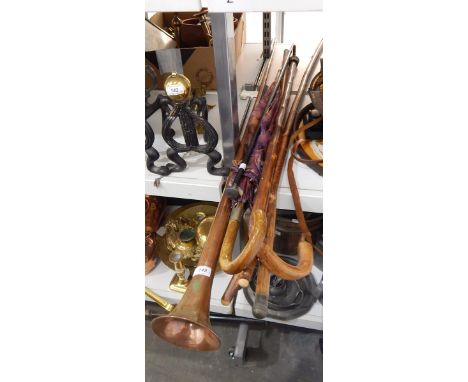 Copper hunting horn, an ebonised walking stick with silver finial and further walking sticks, umbrellas and canes (6) 