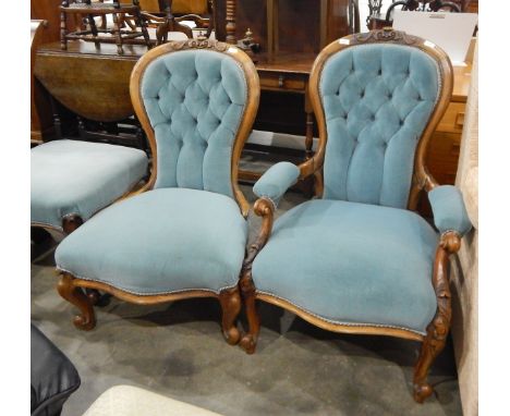 Pair of Victorian ladies and gentlemen's mahogany-framed spindle back, button upholstered chairs, having carved crest rail, t