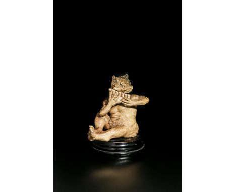 A rare Martin Brothers stoneware Imp Musician by Robert Wallace Martin, modelled seated playing the pan pipes, covered in a b