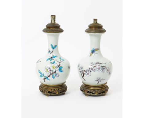 A pair of pottery lamp bases  probably by Theodore Deck, bottle form. painted with butterflies flying past boughs of flowerin