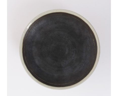 ‡ Dame Lucie Rie D.B.E (1902-1995) and Hans Coper (1920-1981) a stoneware plate, the exterior glazed pale grey to the rim, th