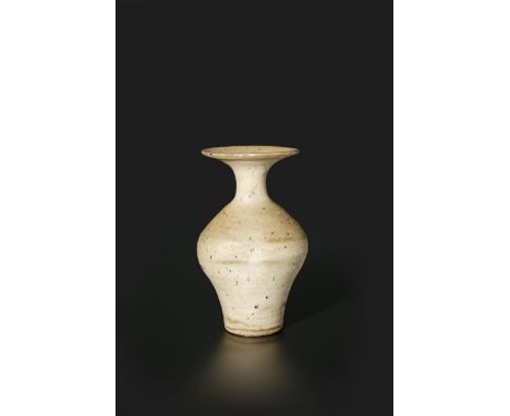 ‡ Dame Lucie Rie DBE (1902-1995) a stoneware bottle vase, with ovoid body and flaring rim, covered in a pitted and speckled b