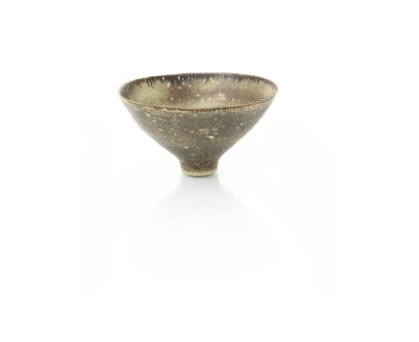 ‡ Dame Lucie Rie DBE (1902-1995) a small footed stoneware bowl, covered to the foot rim with a pitted and bubbled brown glaze