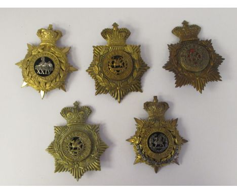 A 24th Regiment of Foot officer's helmet plate, a South Wales Borderer's officer's helmet plate and three soldiers' helmet pl