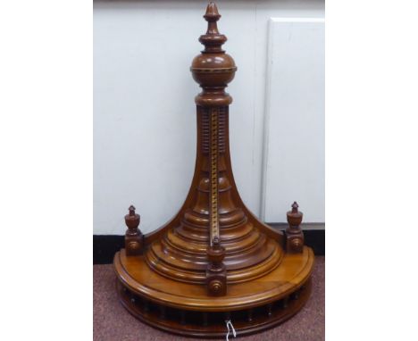 A late Victorian mahogany and marquetry semi-circular wall bracket with a spindled gallery, over a turned, tapered support an