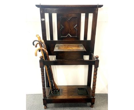 A 1920's oak hat and umbrella stand, W. 85cm, H. 143cm, together with a group of walking sticks.