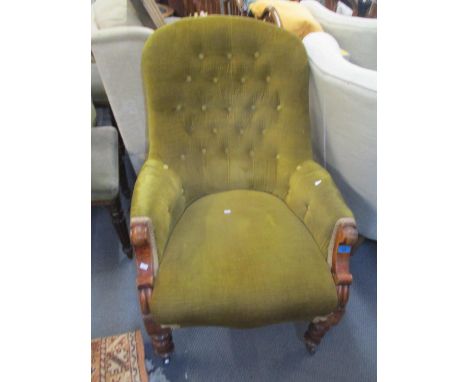 A Victorian walnut button back salon armchair having turned legs and castors 