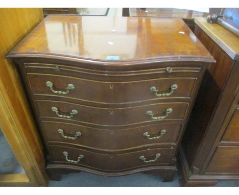 A reproduction Georgian style, serpentine fronted gentleman's dressing chest with brushing slide, four graduated drawers flan
