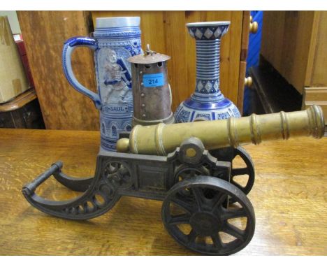 A German stoneware jug and vase, a brass and iron model cannon and a minors lamp 