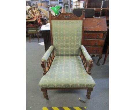 A late Victorian walnut upholstered open armchair on turned front legs and ceramic castors 