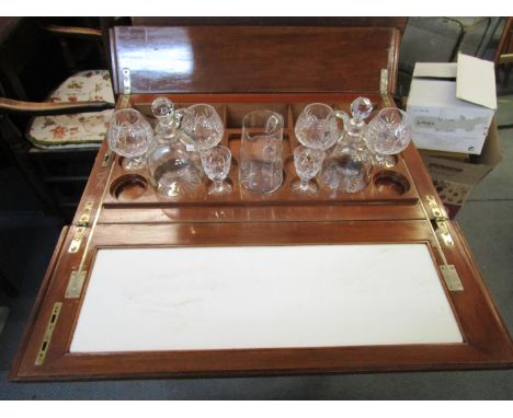 An Edwardian inlaid mahogany rising topped drinks cabinet, with a twin flap top containing glassware on square tapering legs,