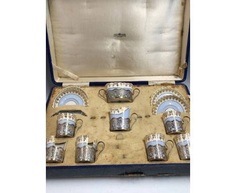 A CASED SILVER MOUNTED CRESCENT PORCELAIN COFFEE SET BY ALEXANDER CLARK, BIRMINGHAM 1928, EACH PIECE WITH GILT TREFOILS ENCLO