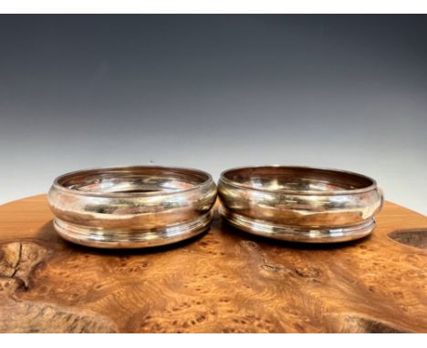 A PAIR OF SILVER WINE COASTERS BY APSREY, LONDON 1987, EACH WITH WOODEN INSET.   13.5cms.