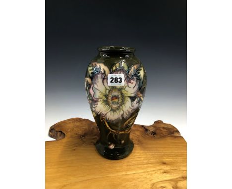 A MOORCROFT BALUSTER VASE SLIP TRAILED WITH SPIKEY HIBISCUS FLOWERS ON A DARK OLIVE GROUND, 1998 COPYRIGHT AND OTHER MARKS.  