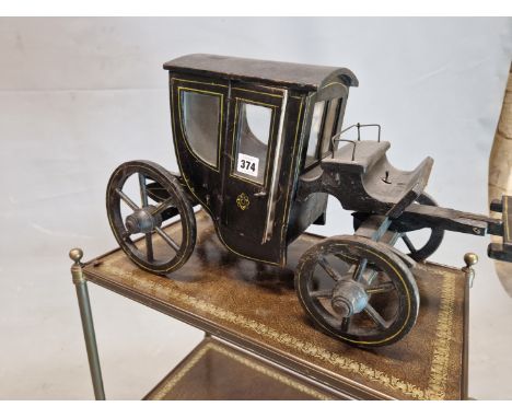 A WOODEN MODEL HACKNEY CARRIAGE PAINTED IN BLACK WITH DETAILS IN YELLOW LINES, THE FOUR WHEEL VEHICLE TO BE PULLED BY A SINGL