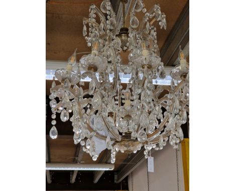 A TEN BRANCH CHANDELIER, EACH ARM HUNG WITH DROPS AND CURVING UP TO MEET THE CEILING SUSPENSION.   H APPROXIMATELY 75cms.