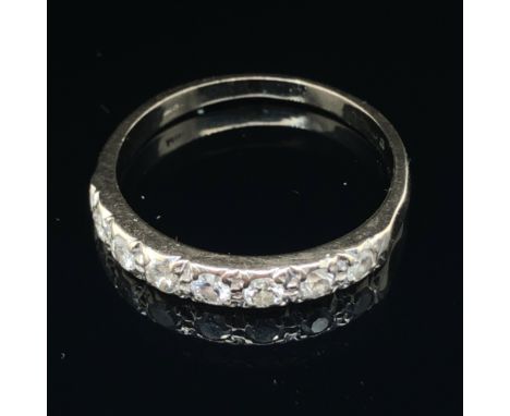 A VINTAGE SEVEN STONE DIAMOND SET HALF ETERNITY RING. HALLMARKS WORN, SOME READABLE, ASSESSED AS 18ct WHITE GOLD. FINGER SIZE