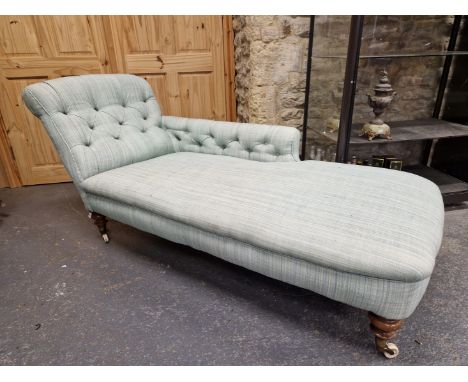 A VICTORIAN CHAISE LONGUE BUTTON UPHOLSTERED IN PALE BLUE, THE TURNED FRONT LEGS ON WHITE CERAMIC CASTER FEET