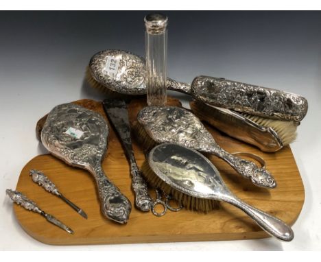 A SILVER BACKED DRESSING TABLE SET, BIRMINGHAM 1924, EACH PIECE WITH A MAN PLAYING A MANDOLIN TO TWO SEATED LADIES. FOUR SILV