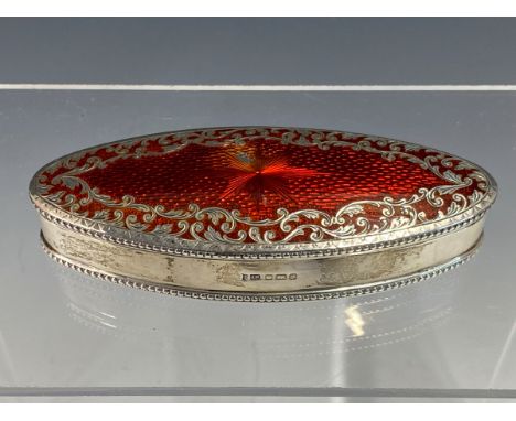 A RED ENAMELLED OVAL SILVER BOX BY JULIUS ROSENTHAL, LONDON 1933, THE BASSE TAILLE HINGED LID WITH A FOLIATE BAND AND BEADED 