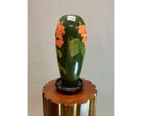 A MOORCROFT TABLE LAMP, THE GREEN SLENDER OVOID SHAPE SLIP TRAILED WITH IRISES.   H 32cms.  WITH A WOOD STAND