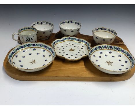 THREE LOWESTOFT TEA BOWLS, A COFFEE CUP, TWO SAUCERS AND A TEA POT STAND. ALL PAINTED WITH CORNFLOWER SPRIGS