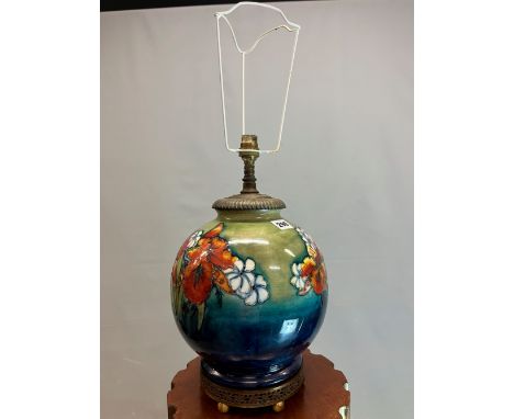 A MOORCROFT TABLE LAMP SLIP TRAILED WITH IRISES AND OTHER FLOWERS ON AS SHADED TURQUOISE GREEN GROUND. H 19cms.