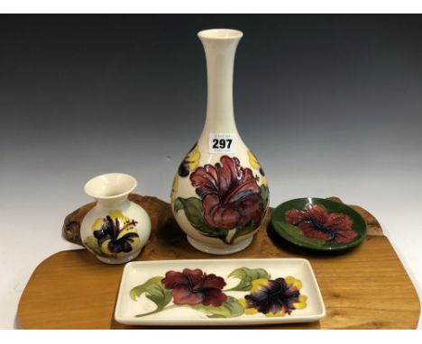 TWO WHITE GROUND MOORCROFT VASES, A RECTANGULAR DISH AND A CIRCULAR GREEN GROUND DISH EACH SLIP TRAILED WITH HIBISCUS FLOWERS