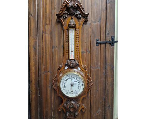 A LATE VICTORIAN OAK CASED ANEROID BAROMETER WITH THERMOMETER OVER.