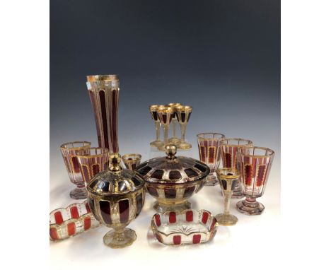 A COLLECTION OF BOHEMIAN GLASS GILT AND OVERLAID BY RUBY PANELS, COMPRISING: FIVE WINE GLASSES, SIX LIQUEUR GLASSES, TWO BOXE