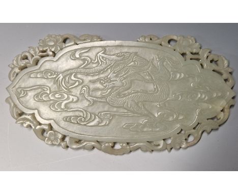 A CHINESE NEPHRITE JADE PLAQUE CARVED IN RELIEF WITH AN ELEPHANT ON ONE SIDE AND WITH A DRAGON ON THE OTHER. W 15cms.