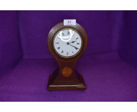 An Edwardian mahogany mantel clock having inlaid detail to waisted front and roman numerals to enamel face,key included.