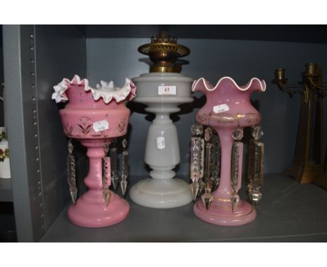 Two antique pink glass mantel lustre's and a oil lamp.