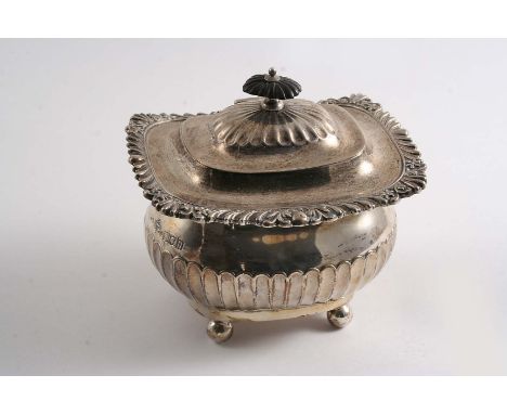 AN EDWARDIAN SUGAR CADDY  of rounded oblong form with ball feet, and a part-fluted lower body & cover, with gadroon & foliate