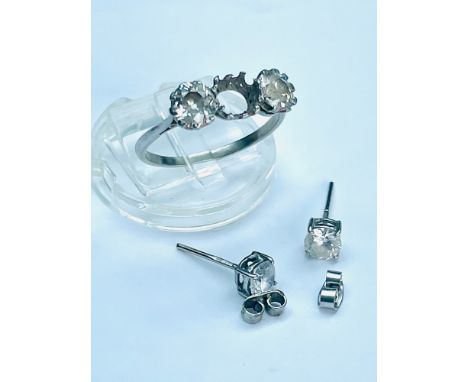 A white metal three stone ring set with two round brilliant cut diamonds in a claw setting, total weight of diamonds 1.40 car