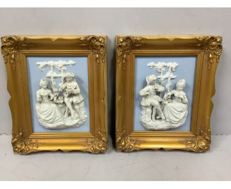 A pair of relief moulded ceramic panels, each with an 18th century courting couple conversing and playing instruments, in orn