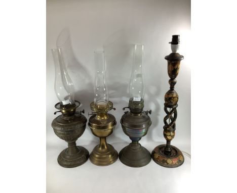 Three various brass oil lamps (lacking shades) together with a Kashmiri papier-mache candlestick converted to a lamp (4) 