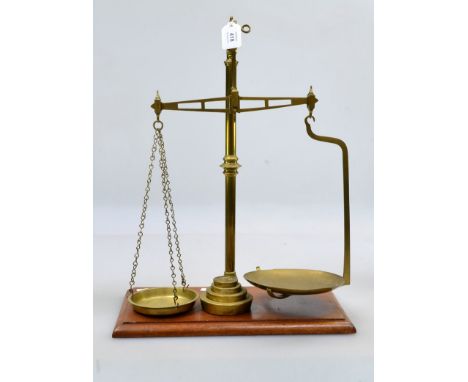 A set of 19th century brass pan scales, on a mahogany plinth with weights