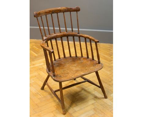 A 19th century yew Windsor armchair, having eared rail, double comb back, elm seat on turned splayed legs united by an H stre