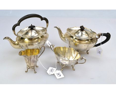 An Edwardian three piece tea-set, of scalloped oval form, on scroll-mounted bifurcated paw feet, the teapot with ebonised han