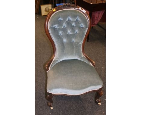 A Victorian walnut spoon back nursing chair, with floral carved cresting rail and button upholstery, raised on cabriole suppo