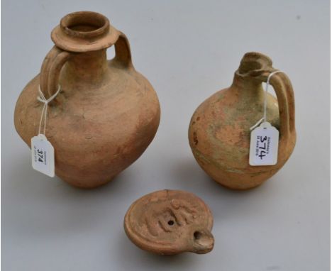 A Roman terracotta oil lamp, moulded with an elephant, wine flask and a jug