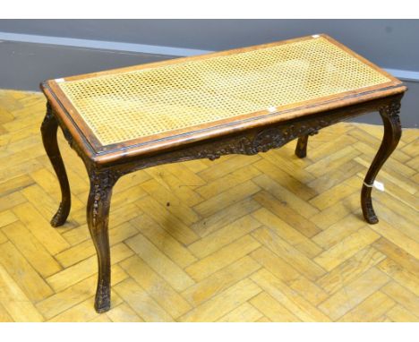 An Edwardian carved and cane panelled long stool, with shaped cabriole supports, 100cm long