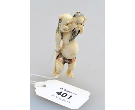 A 19th century Japanese carved and stained netsuke, in the form of an oni holding a mask of the God of War, 6cm long