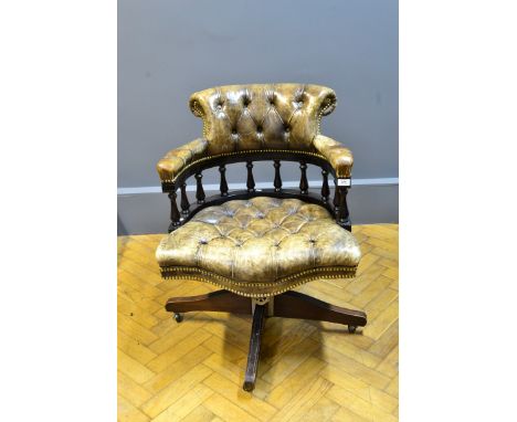 A reproduction olive button green leather upholstered swivel reclining captain's chair