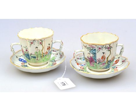 A pair of Qain Long, famille rose trembleuse twin handled cups and saucers, each decorated with reserves of figures and lands