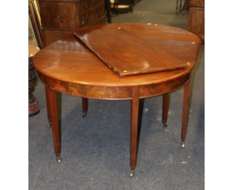 A George III mahogany dining table, having two D ends, each with double gate and two leaves, on square tapering legs with bra