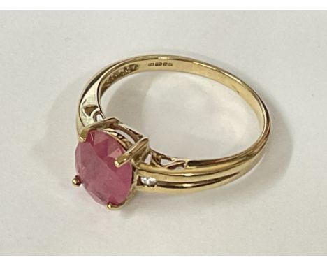9ct yellow gold ring set with oval ruby flanked by white sapphires. Ruby 1.25ct approx. Sapphires 0.02ct approx. Ring size ap