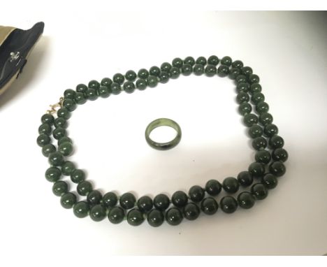 A Vintage dark green jade necklace with matching ring. (2)
